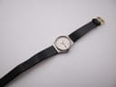 Full view of the Zenith Espada watch with its black leather strap laid flat, showcasing the gold-tone buckle.