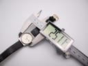 Digital caliper measuring the Zenith Espada watch case diameter, displaying 25.1mm on the screen.