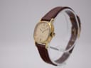 Angled side view of the Rado Silhouette watch on a display stand, highlighting the gold cushion case and textured crown.