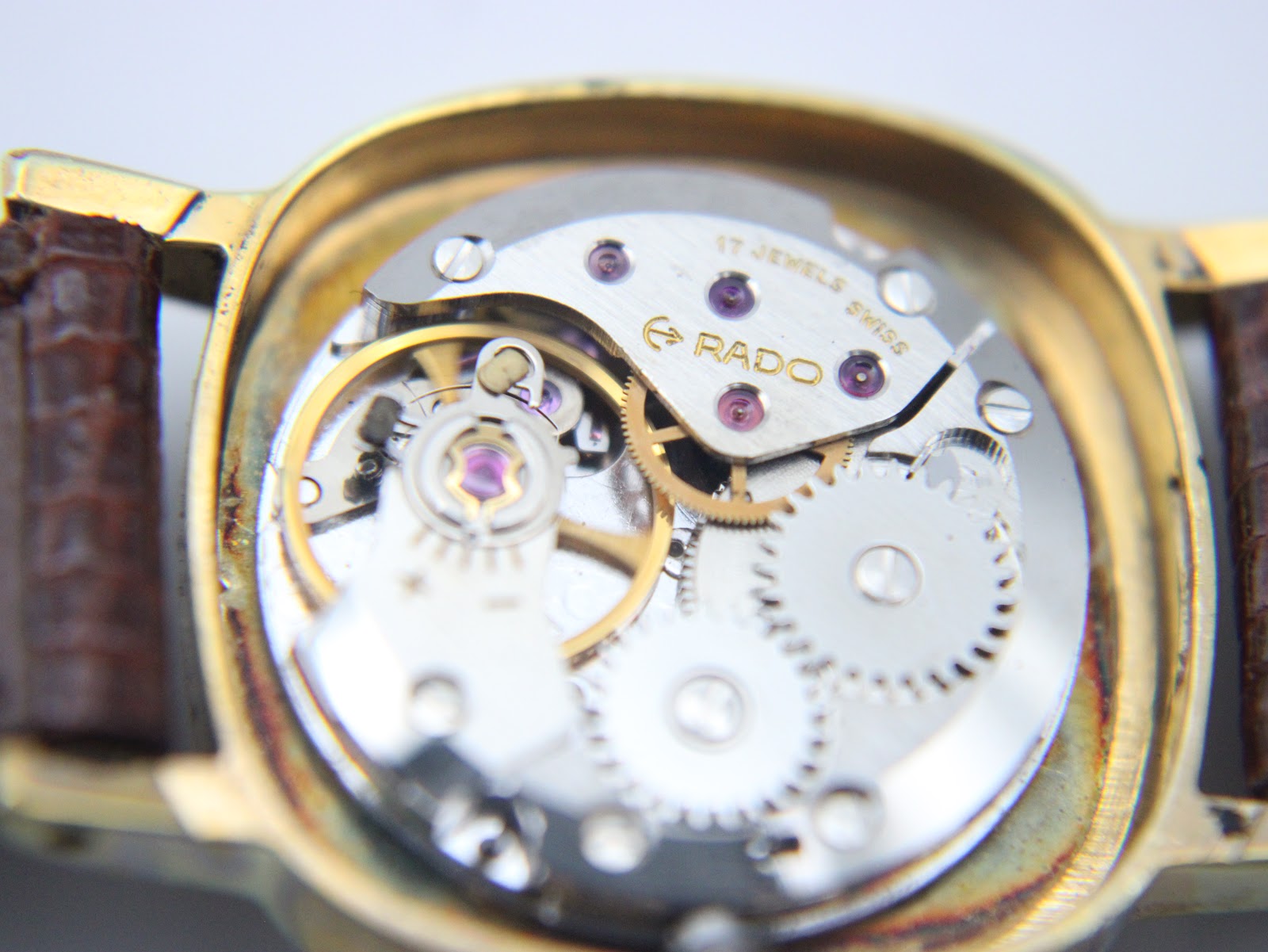 Macro shot of the Rado 17-jewel manual wind movement, revealing intricate gears and 'RADO SWISS' engraving.