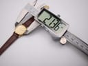 Digital caliper displaying a precise measurement of 21.36mm across the Rado watch case.