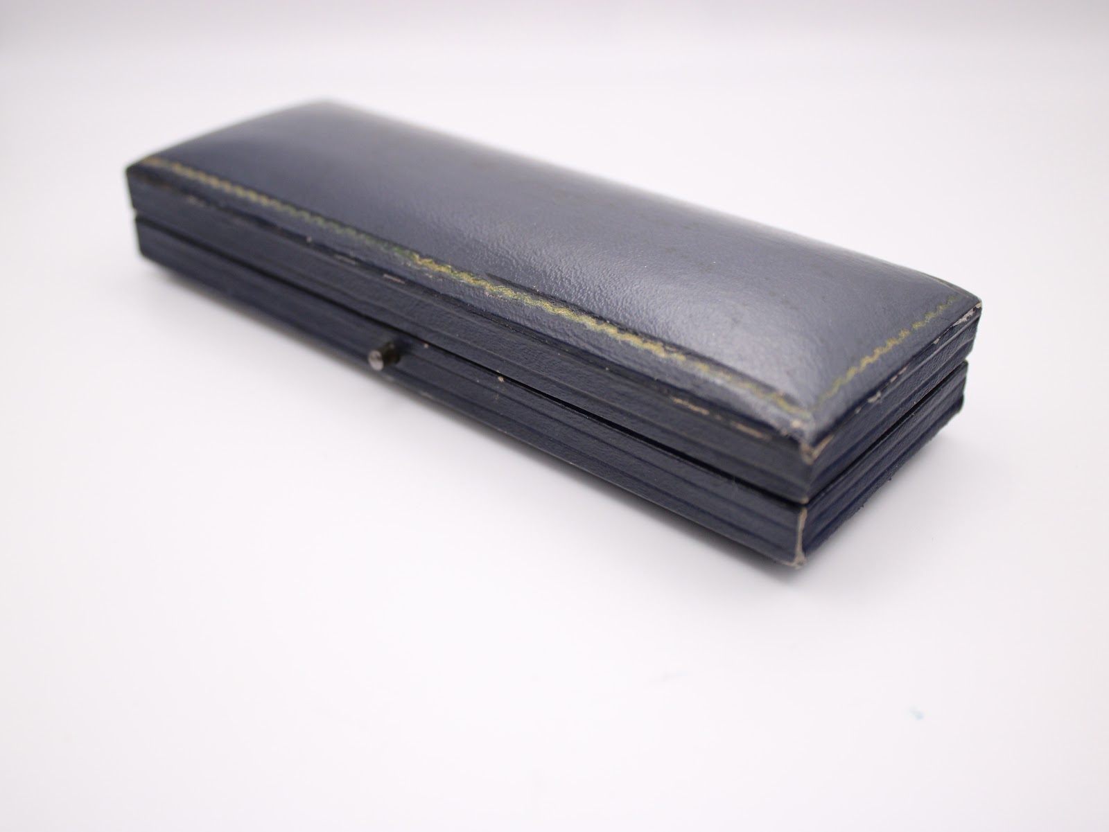 Closed view of the vintage navy blue Perry Greaves Birmingham watch box, showing its textured exterior.