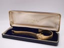 Open blue Rotary watch box with a gold tone watch resting inside on a velvet cushion, showing the watch from an angle.