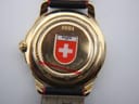Close-up of the watch's gold tone case back, engraved with '1991', 'WATER RESISTANCE', and a Swiss shield emblem.