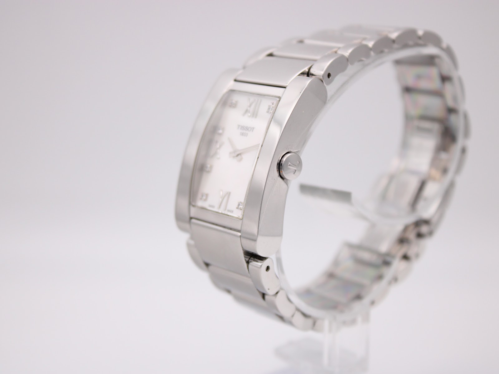 Side view of the Tissot t007309 a watch on a stand, showing the right side of the rectangular case and crown.