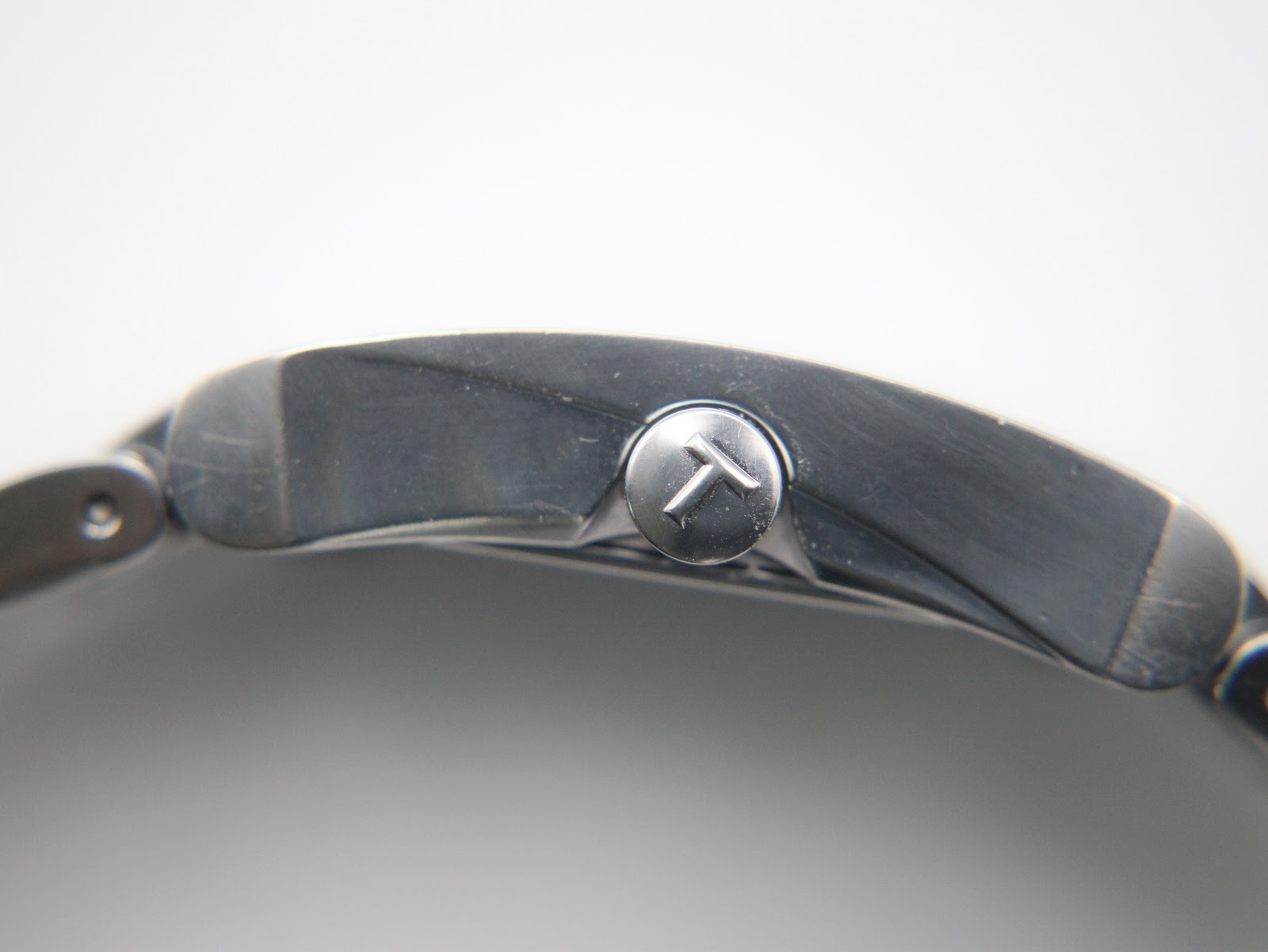 Close-up of the Tissot-signed crown on the side of the watch case.