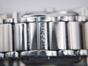 Close-up of the Tissot logo engraved on the folding clasp of the stainless steel bracelet.