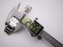 Digital caliper measuring the Tissot watch case width at 24.95 mm, showing the precise measurement.