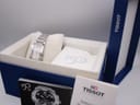 The Tissot watch displayed inside its original blue box with a cream inner cushion and booklets.