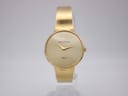 Front view of a vintage Michel Herbelin watch with a champagne dial and gold-tone integrated bracelet, on a white background.
