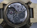 Close-up of the manual wind watch movement, revealing gears, jewels, and the intricate mechanical components.