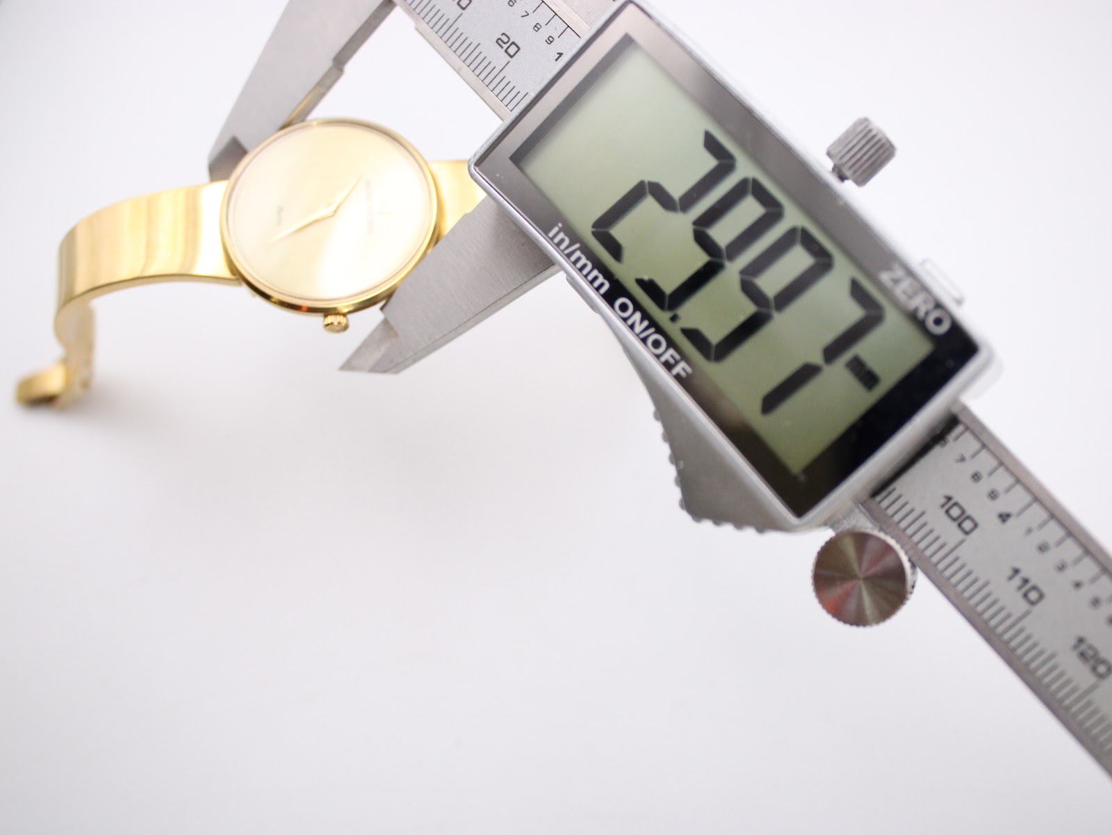 A digital caliper measuring the case diameter of the Michel Herbelin watch, displaying a precise reading of 23.97mm.