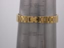 The gold-tone integrated bracelet of the watch shown on a metal wrist sizing gauge, indicating a circumference of approximately 168.5mm.