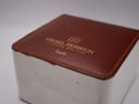 Exterior view of the original Michel Herbelin watch box, featuring a brown faux leather top with gold embossed branding.