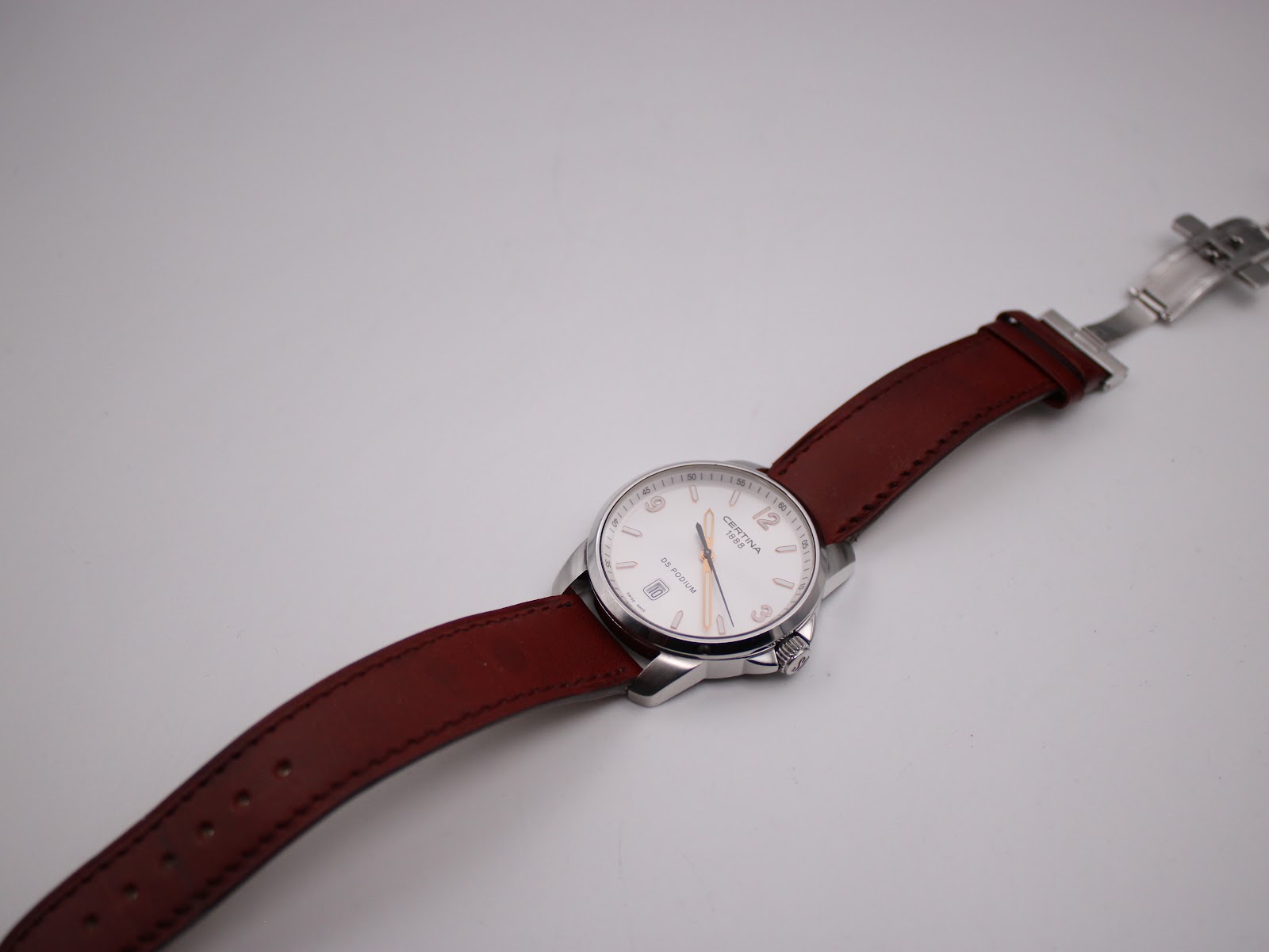 Top-down view of the Certina DS Podium with the brown leather strap unfurled, showing the deployant clasp.