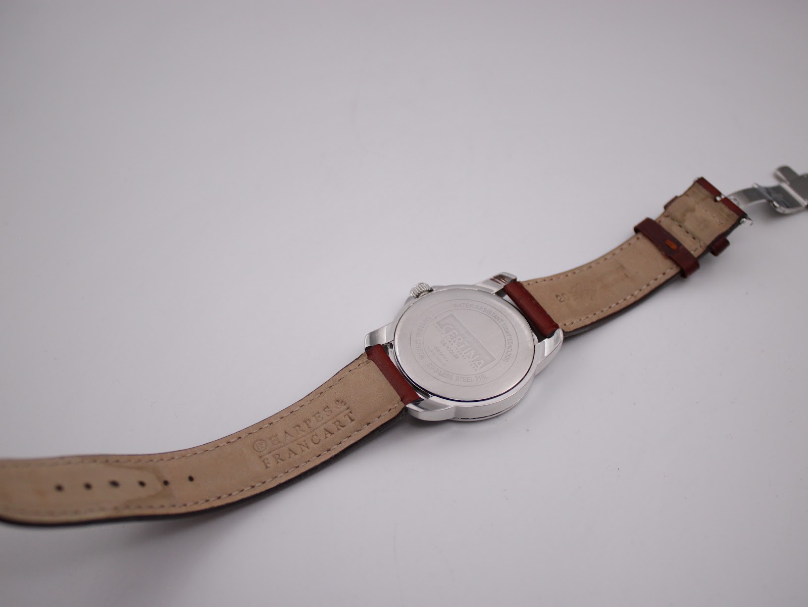 Back view of the Certina DS Podium with the brown leather strap unfurled, showing case back and strap markings.