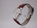 Side-angle view of the Certina DS Podium showing the polished case and crown, with brown leather strap on a stand.