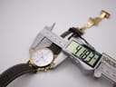 Watch case being measured by a digital caliper, displaying "41.83 mm" for the case diameter. The strap and clasp are visible in the background.