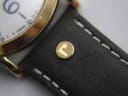 Close-up of the brown leather strap showing a gold-toned rivet with the Roamer 'R' logo.