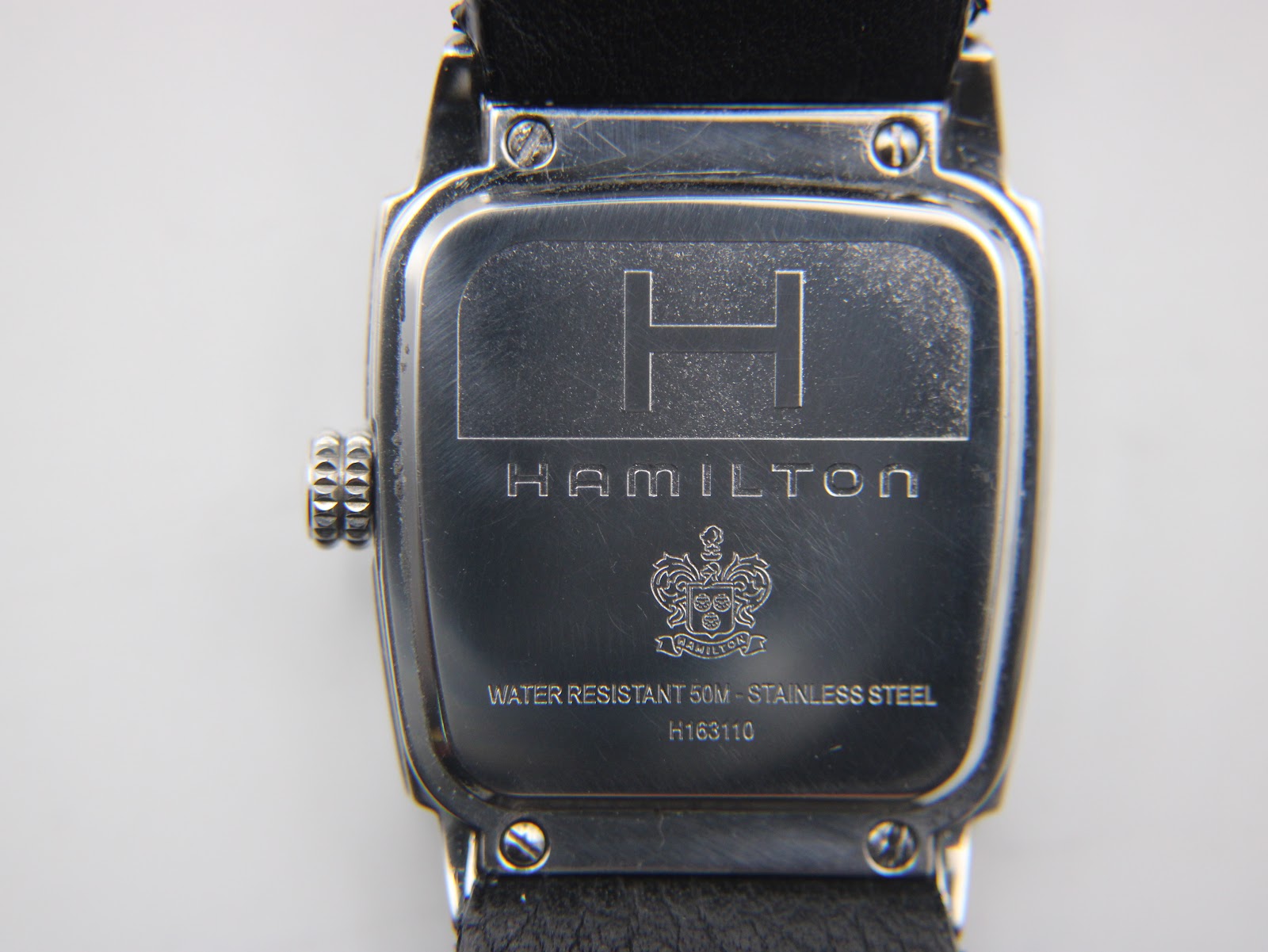 Close-up of Hamilton H163110 case back, showing 'Hamilton', 'Water Resistant 50M', 'Stainless Steel', and model number H163110.