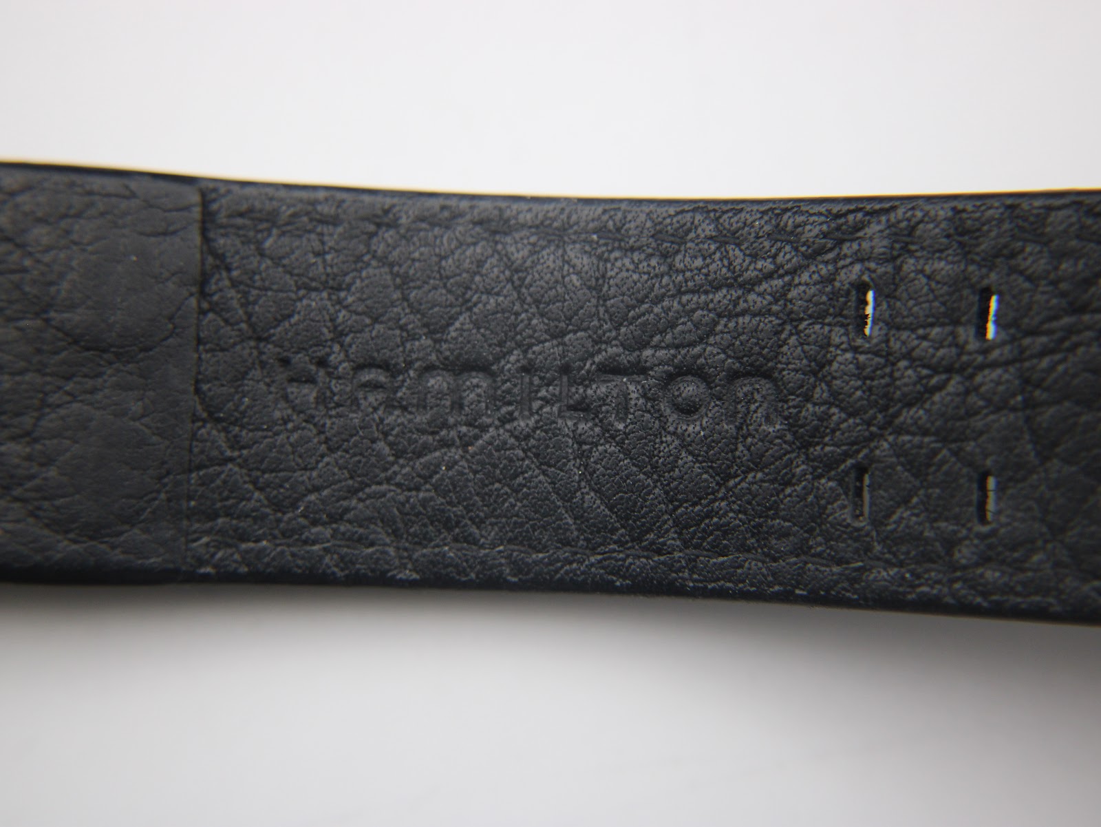 Close-up of the underside of the black leather strap, showing the embossed 'Hamilton' logo.