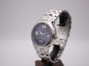 Angled view of Gianni Sabatini watch on a stand, showing the blue dial and integrated steel bracelet.