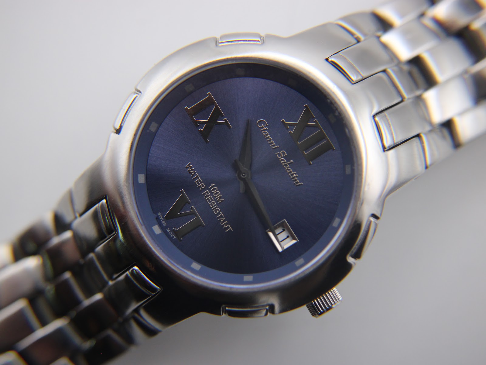 Detailed view of the Gianni Sabatini blue dial with applied silver Roman numerals, stick markers, and date window at 3 o'clock.
