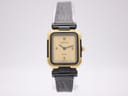 Front view of the Certina Ibiza watch on a white display stand, showing the cream dial and gold rectangular case