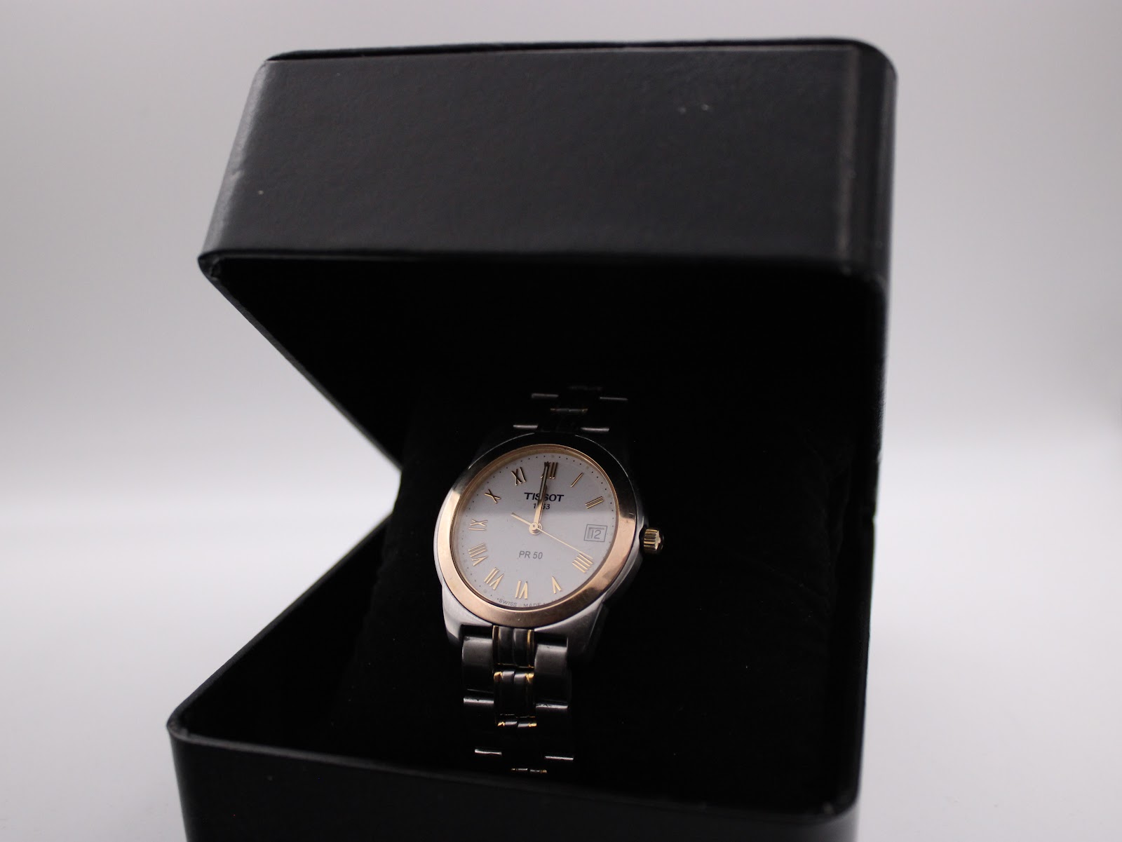 The Tissot PR 50 watch nestled inside a plain black presentation box.