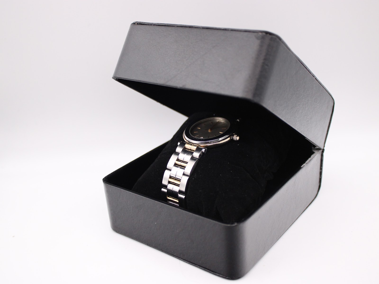 The Michel Herbelin Newport watch placed inside a black display box on a velvet cushion.