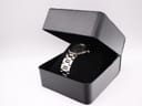 The Michel Herbelin Newport watch placed inside a black display box on a velvet cushion.