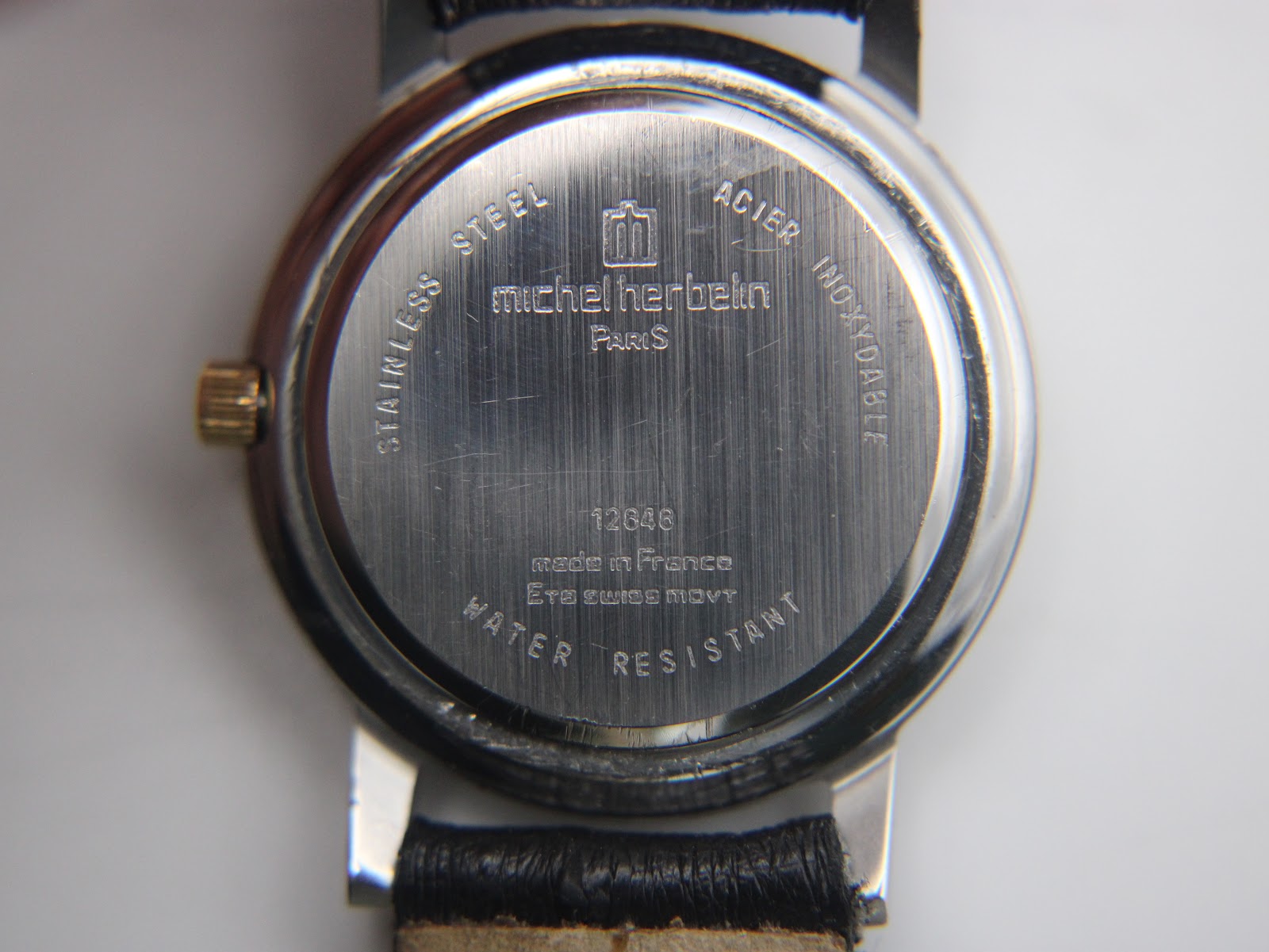 Close-up of the stainless steel case back of the Michel Herbelin watch, showing model number and 'made in France ETA swiss movt'.
