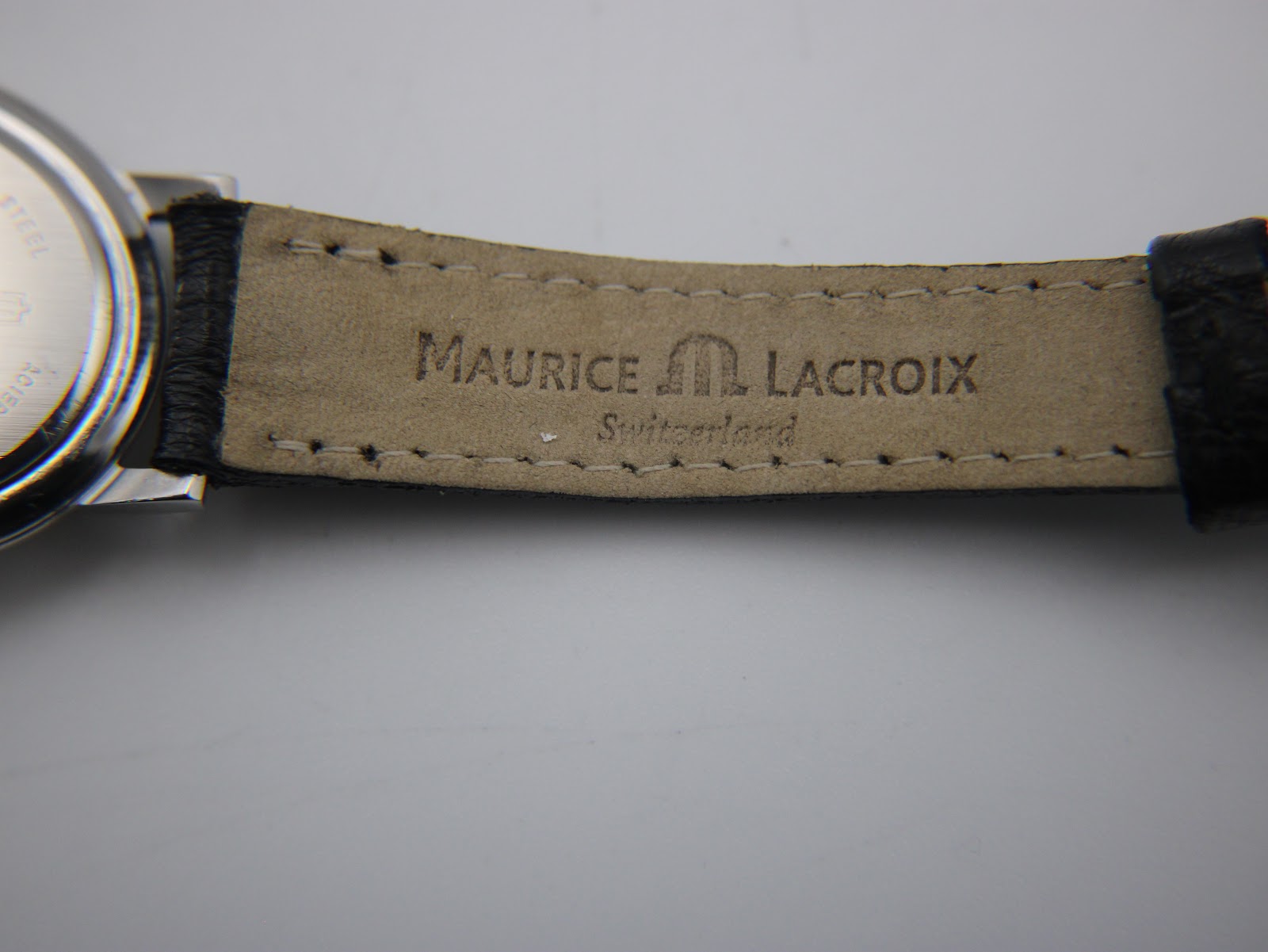Underside of the black leather strap, showing 'Maurice Lacroix Switzerland' branding.