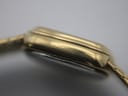 Detailed side view of the watch case, showing an engraving 'PLAQUE G 10M' indicating 10-micron gold plating, with some minor wear visible.