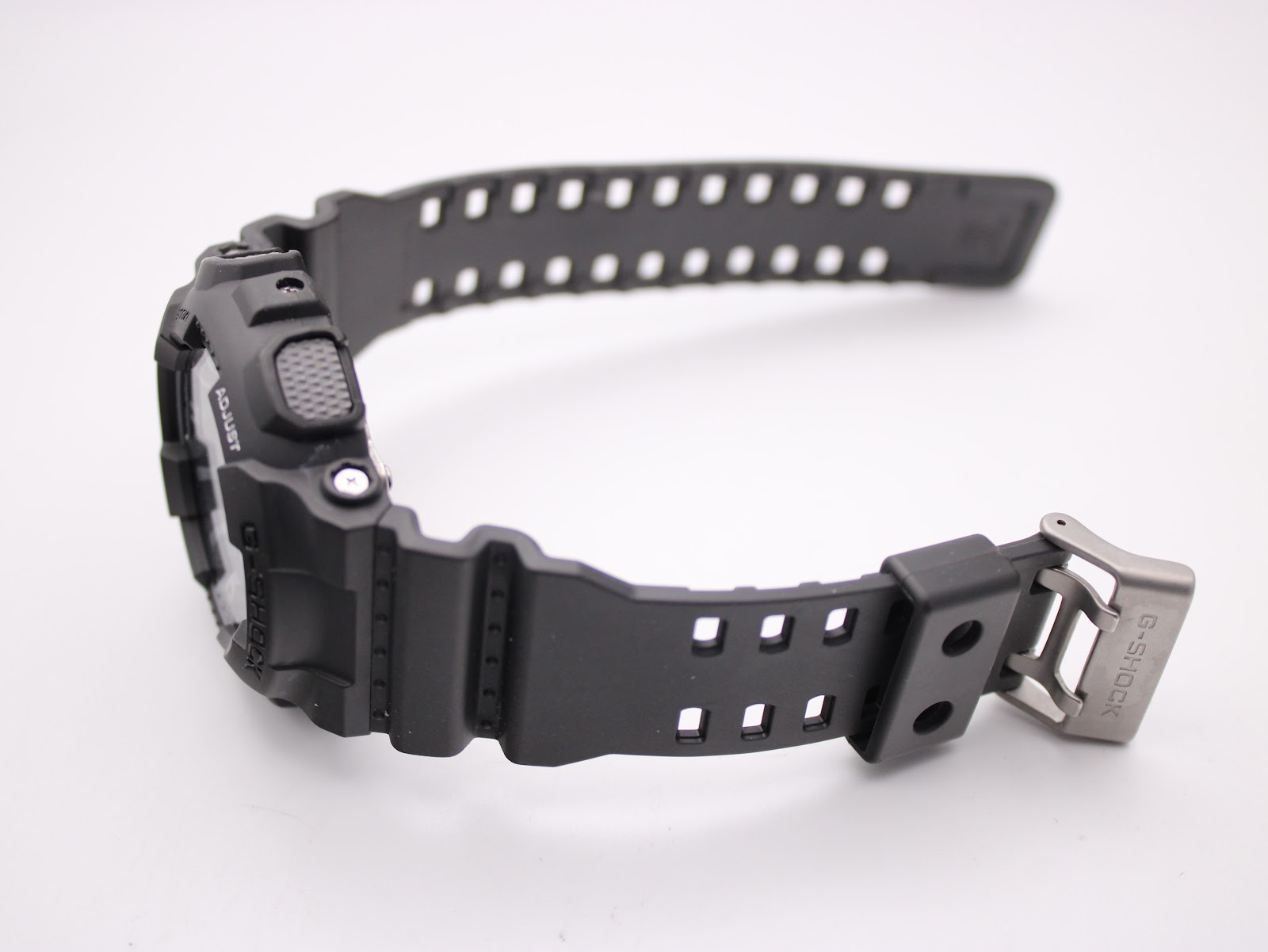View of the black resin strap of the Casio G-Shock GA-110C, showing the signed stainless steel buckle with "G-SHOCK" engraving.