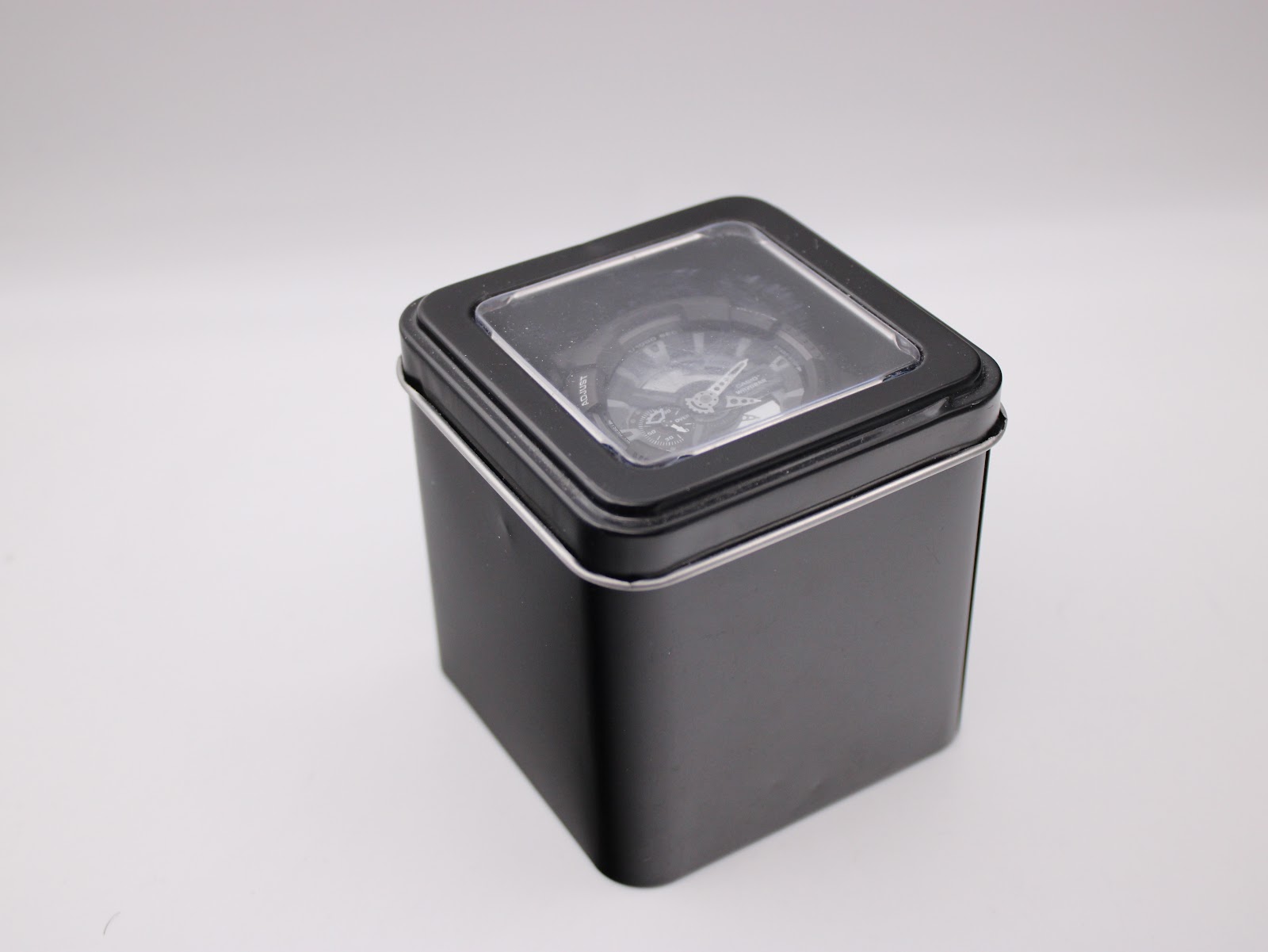 Closed black metal G-Shock tin containing the Casio GA-110C watch.