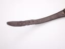 Close-up detail of the worn end of the brown leather strap, revealing visible creasing and slight damage around the buckle holes.