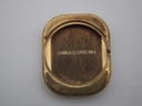 Interior view of the watch case back, showing the 'Stainless Steel Back' engraving and gold-toned finish.