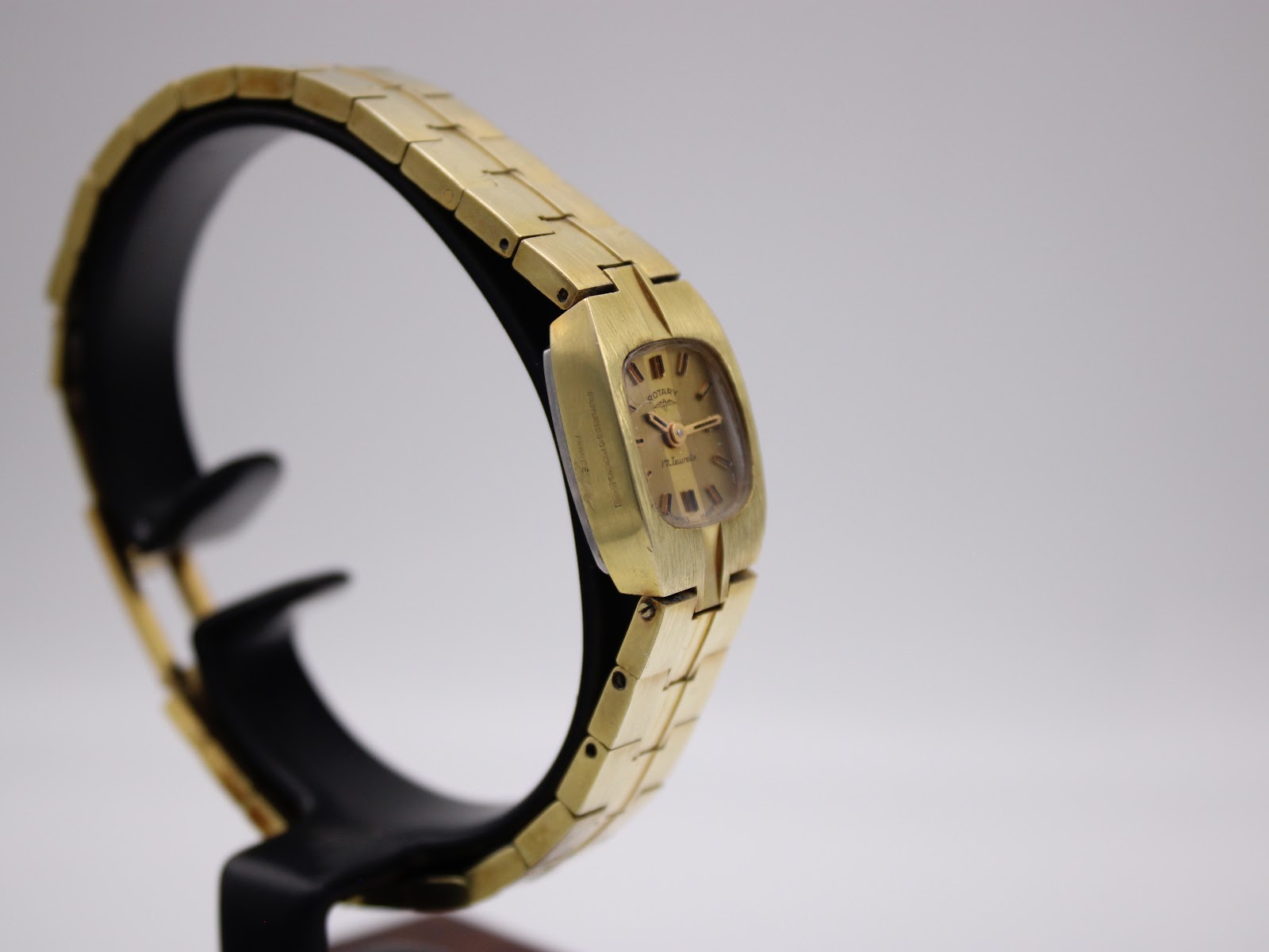 Side-angled view of the Rotary watch on a display stand, focusing on the slender case profile and the texture of the bracelet links.