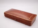 Closed view of the vintage brown Goldsmiths & Silversmiths presentation box with gold detailing.