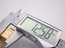 Digital caliper measuring the case width of the Rotary watch, displaying 12.58mm on the screen.