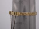 The gold tone mesh bracelet of the watch wrapped around a wrist sizing gauge, indicating a wrist circumference of 188mm / 18.8cm.