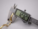 Digital caliper measuring the width of the Gucci 1500L watch case, displaying a precise measurement of 12.32mm.