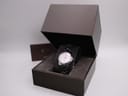 Front view of the Gucci 126.5 watch in its open original dark brown box, with papers visible behind it.
