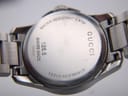 Close-up of the watch case back, engraved with 'GUCCI', '126.5', 'SWISS MADE', '16048342', 'WATER RESISTANT 5 ATM', and 'STAINLESS STEEL'.