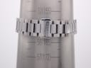 Close-up of the stainless steel bracelet with signed Gucci clasp on a wrist sizing cone, showing a measurement of approximately 155mm.