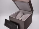 Angled view of the Gucci 103 watch inside its open brown presentation box, with 'Gucci Timepieces' leaflet.