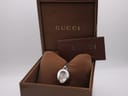 Front view of the Gucci 103 watch inside its original brown presentation box, with accompanying papers.