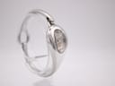 Side view of the Gucci 103 watch on a stand, highlighting the sleek, integrated bangle design and left profile.