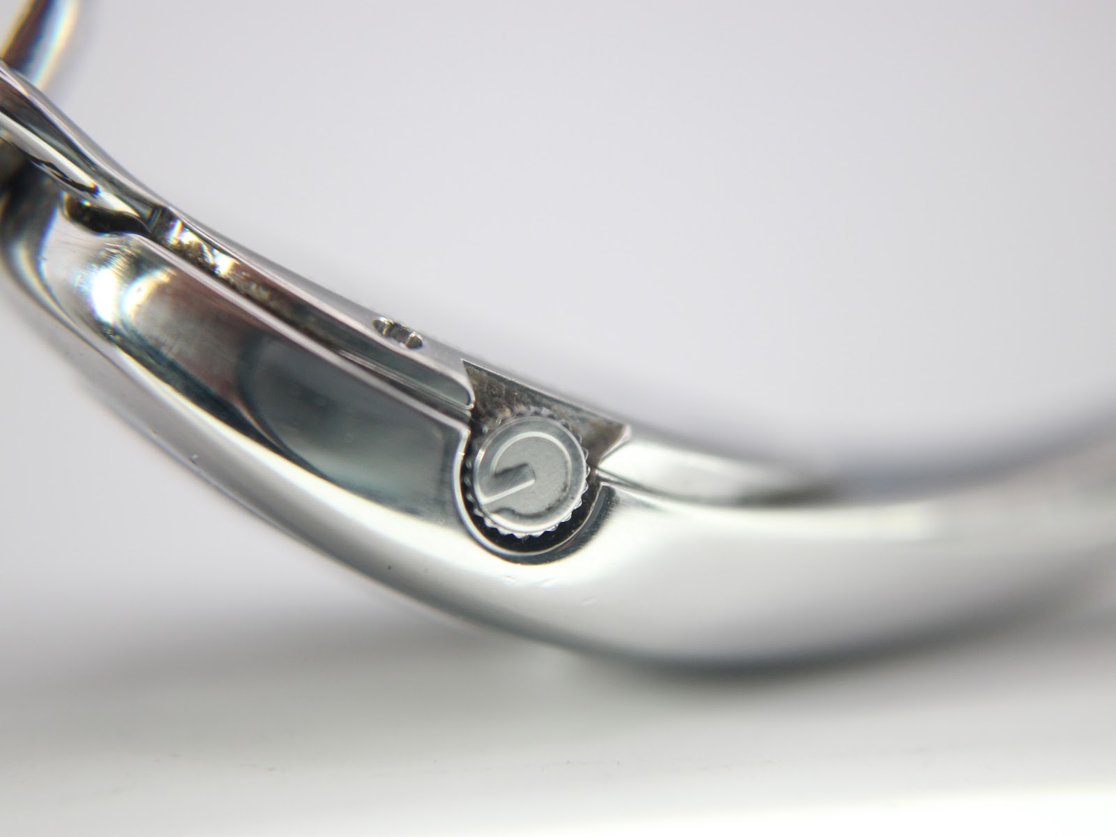 Close-up shot of the watch crown, featuring the Gucci 'G' logo detail on its side.